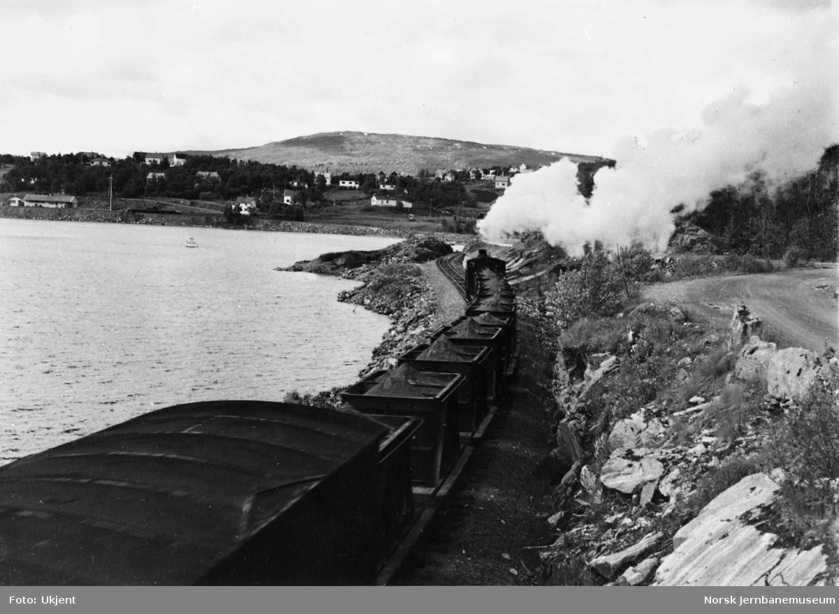 Damplokomotiv med kistog på vei mot Finneid