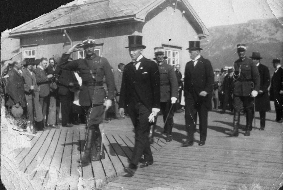 Kronprins Olav (til venstre) på kaia på Sortland ved landsskytterstevnet 1925. Kronprinsen tjenestegjorde som offiser i Nord-Norge på denne tida. Kan mannen til høyre for prinsen være Sortlands ordfører Dag Ellingsen?