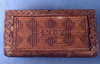 Bokfodral med dekor i form av ristade kvadrater och uddsnittsbård. Lock av senare tillverkning har liknande dekor samt "1702".
Äldre sakord: Låda.