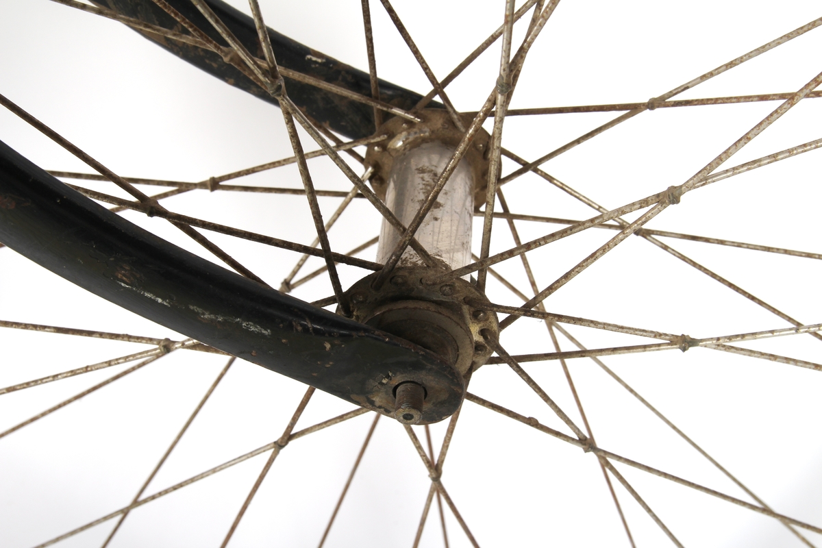 Svartlakkert damesykkel. Hjulene har stålfelger som er ådret for se ut som trefelger. Hjulene er konstruert i klassisk tre-kryss mønster, hvor krysset i framhjulet er surret sammen og loddet. Kjeden er av gammel type, hvor tannhjulene kun griper inn i annet hvert ledd. Sykkelen har Torpedo baknav med innebygd trommelbrems.