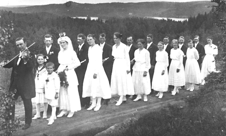 Ödenäs sn. 
Brudfölje vid Bondbröllop.
Bröllopet hölls den 6 juli 1919.
Bilden tagen från "stora landsvägen" och sjön i bakgrunden heter Ören.
Brudparet heter Hanna och Hjalmar, vilka senare reste till Amerika.