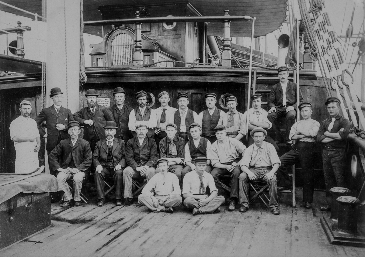 Gruppebilde av 22 av mannskapet på barken "Skjold" av Tvedestrand, tatt på skutedekket.