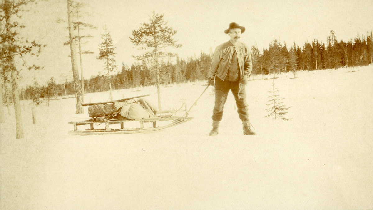 Mann, Karl Galaasen (2/4 1874 - 1962) trekkende på slede i Galåsen.