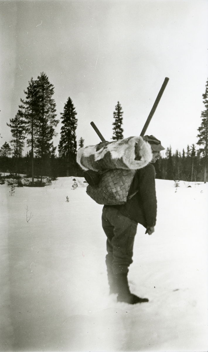 Mann stående i snøen i Galåsen med "neverkont" på ryggen (skinn under lokket).