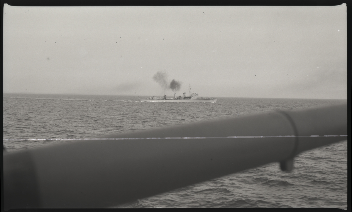 Jagaren NORDENSKJÖLD fotograferad från annat fartyg. Eldrör på kanon i förgrunden.