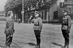 Menn, uniformer, bygninger.