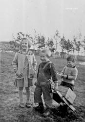 Tre barn, klær, trillebår, 3 unger i lek, Magnhild Olstad, S