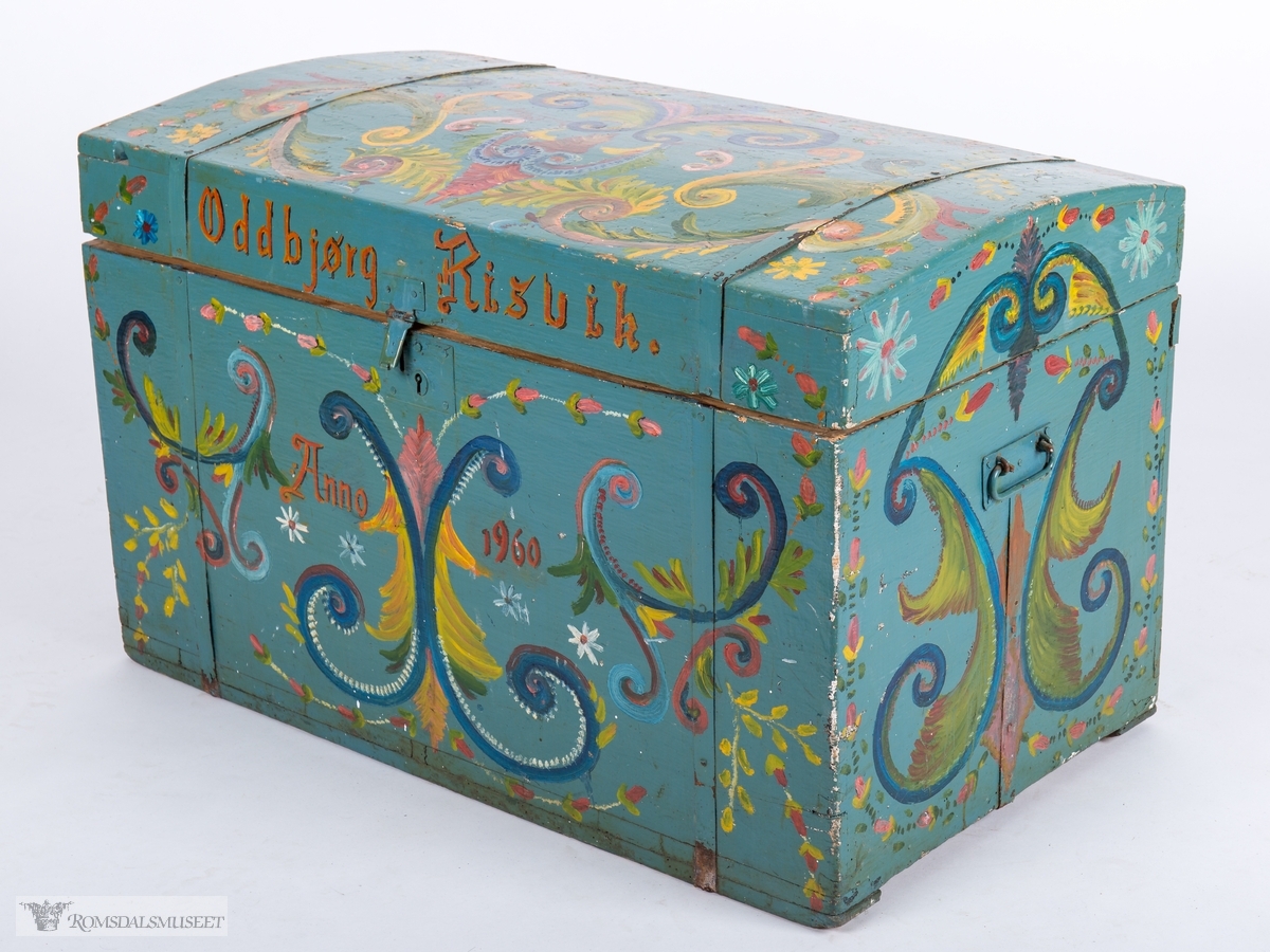 Kista har blågrå bunnfarge og er dekorert med enkel, amatørmessig rosemaling. Akantus, ranker og blomster.