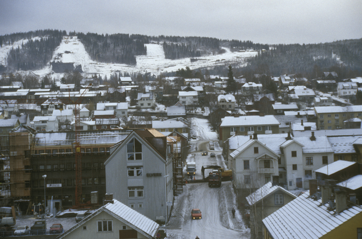 Lillehammer sentrum, krysset Storgata, Tomtegata, veiarbeid i Storgata, bebyggelse, mot øst, Kanthaugen med OL-parken i bakgrunnen, tatt fra YK-huset, 8 etg. Store hjørnebygget til venstre er Elverkets kontorer i Storgata 106.