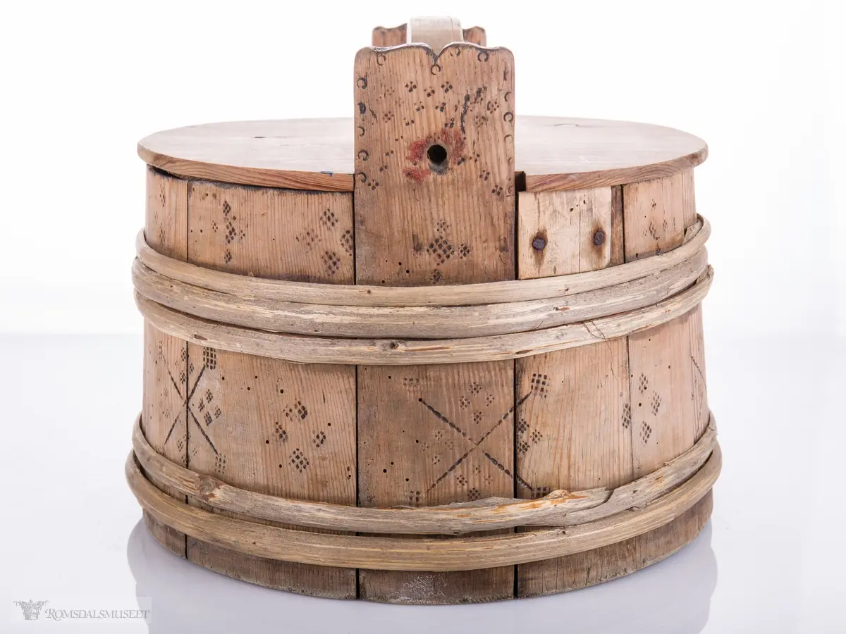 Lagget ambar med ører og lokk med hanke. Omslått med gjorder oppe og nede.