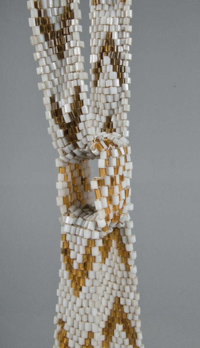 Spjällband av vita och gula glaspärlor, sexkantiga i genomskärning.