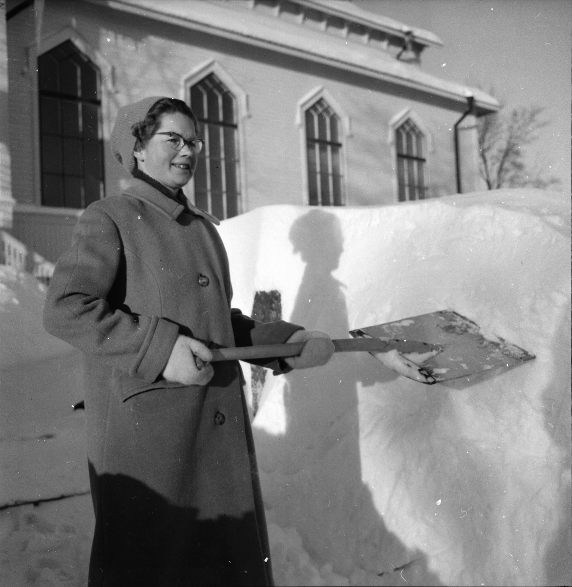 Svea Zättlin skottar snö vid Missionskyrkan i Lingbo.
15/1 1959.