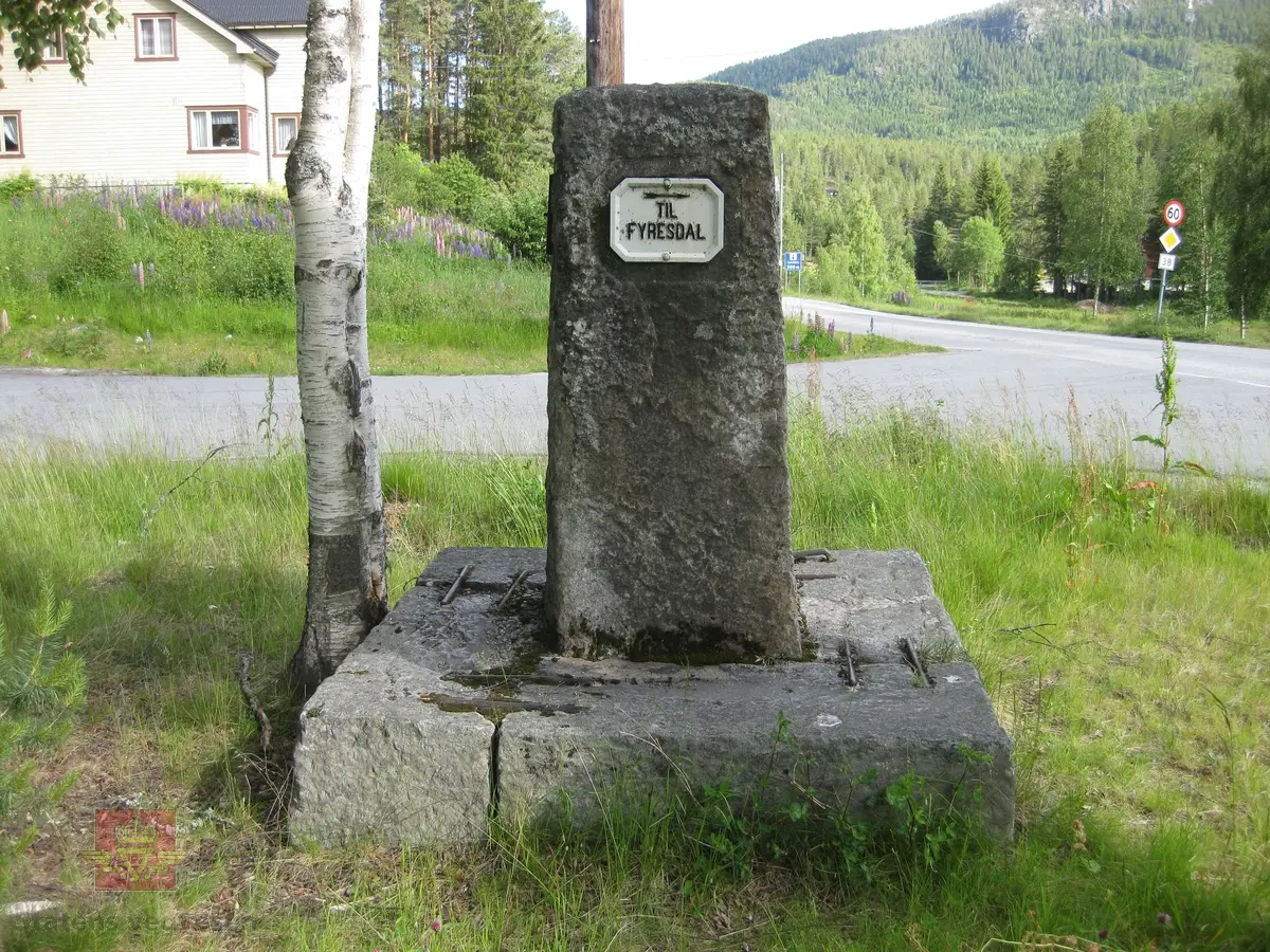 "Ved Krosli 09.08.1926", i følge merking på bildet. På bildet står et stort betongvegmerke med innhugget årstall: "Gjennem Vraadal 1904". Damen på bildet er muligens Christine Baalsrud, vegdirektørens kone. Han står til høyre for henne med skyggelue. Personene nr. 3 og nr. 6 fra venstre er de samme  som er avbildet på bilde NVM 00-F-3579. De er ukjente. 

De neste bildeframvisningene i farger viser "Vegmerke i Krossli." Sitat gjengitt fra Krossli-lokalhistoriewiki.no. Foto: Olav Momrak Haugan: "Krossli er eit vegkryss i Tokke kommune som ligg på vegen frå Bandaksli til Fyresdal. I 2011 går Rv 355 nordover frå Fyresdal til Krossli. Bandakslivegen, vegen fra Bandaksli til Fyresdal, vart i fyste del av 1900-talet grundig utbedra. Frå denne perioden finnast det fleire vegmerke som fortel vegfarande kor vegen fører vidare. Ei slik støtte stod midt i krysset i Krossli, i 2011 står den i utkanten av krysset. Litt lenger sør vert ein gjort merksam på at ein kryssar grensa til Fyresdal, etter fyrst å ha vore eit lite stykke gjennom Kvitseid kommune". 

Ref. til verneplanen "Vegvalg-Nasjonal verneplan for veger, bruer og vegrelaterte kulturminner. Statens vegvesen-Region Sør". Jfr. "202 Bandaksli", side 206. Se vedlegg.