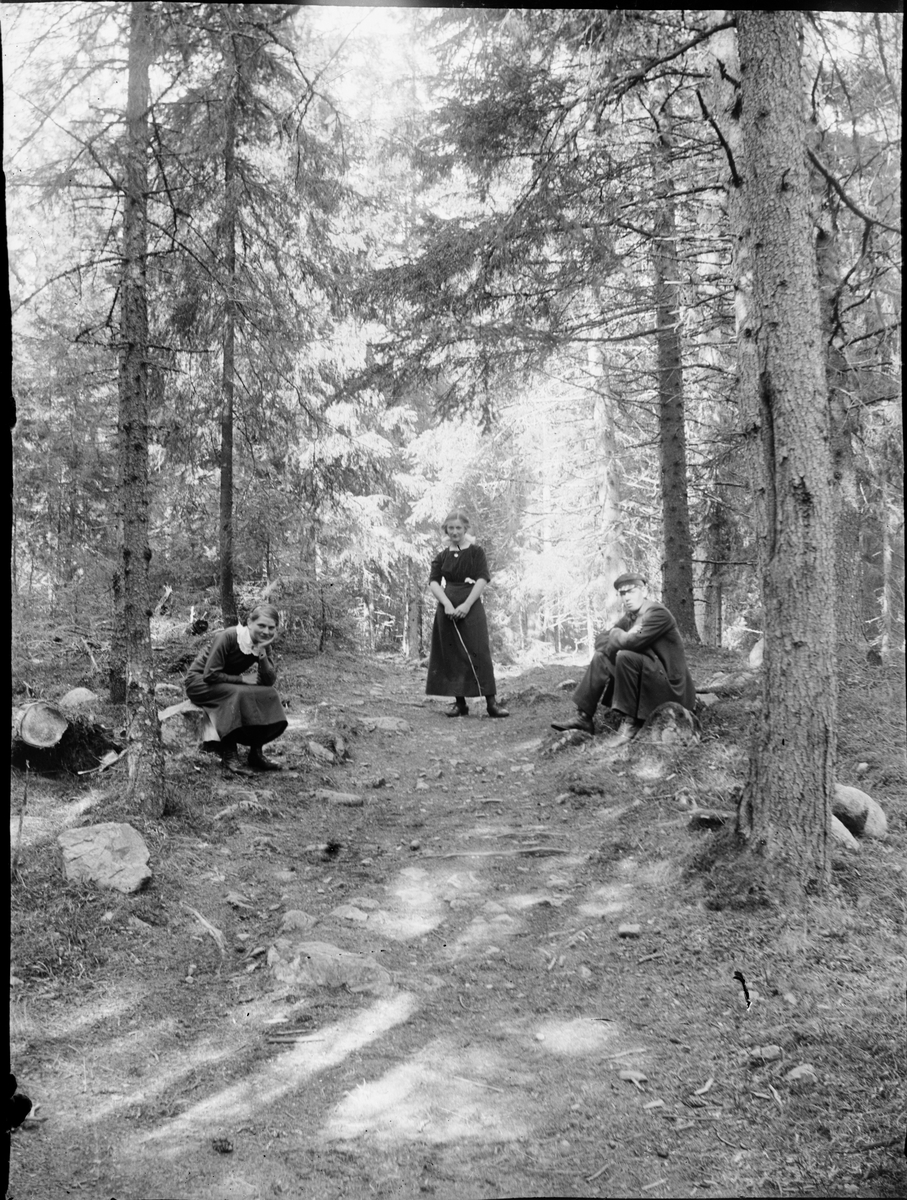 Två kvinnor och en man vid skogsstig, Östhammar, Uppland