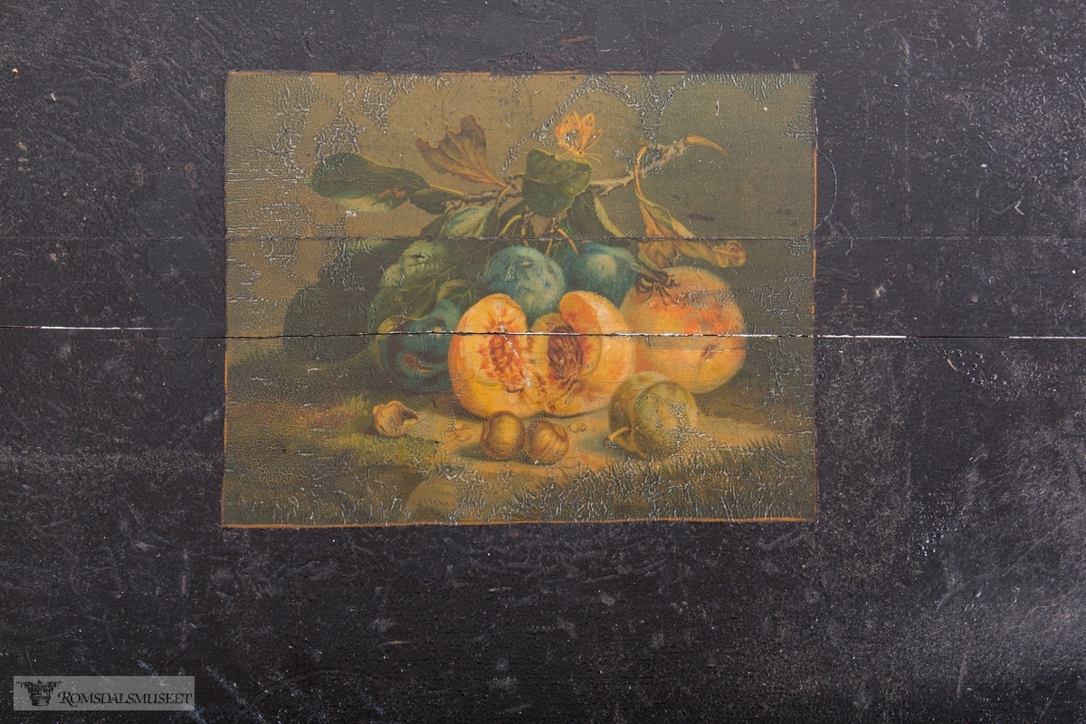 Et stilleben sentralt på bordplaten av en klase med plommer, to fersken, den ene brutt åpen, to nøtter og en fiken.