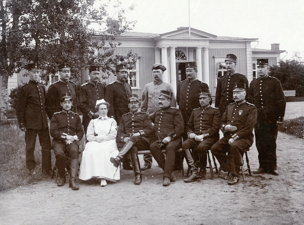 Grupporträtt av sjuksyster med officerare vid beväringsrekrytskolan i Hultsfred, 1907.