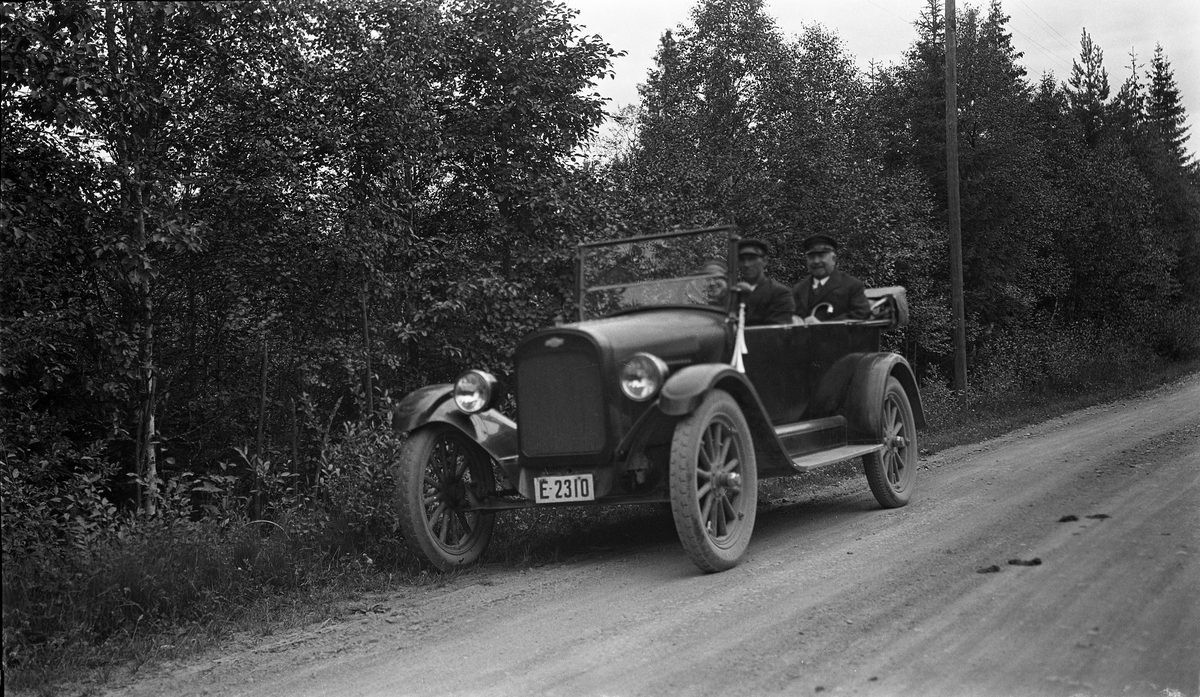 Tre personer i en Chevrolet, ca. 1923-25.
Bilen er muligens eid av Kristian Rogne på Kraby i Østre Toten, og kanskje er det han som sitter ved rattet. Ellers er hverken personer eller sted identifisert.