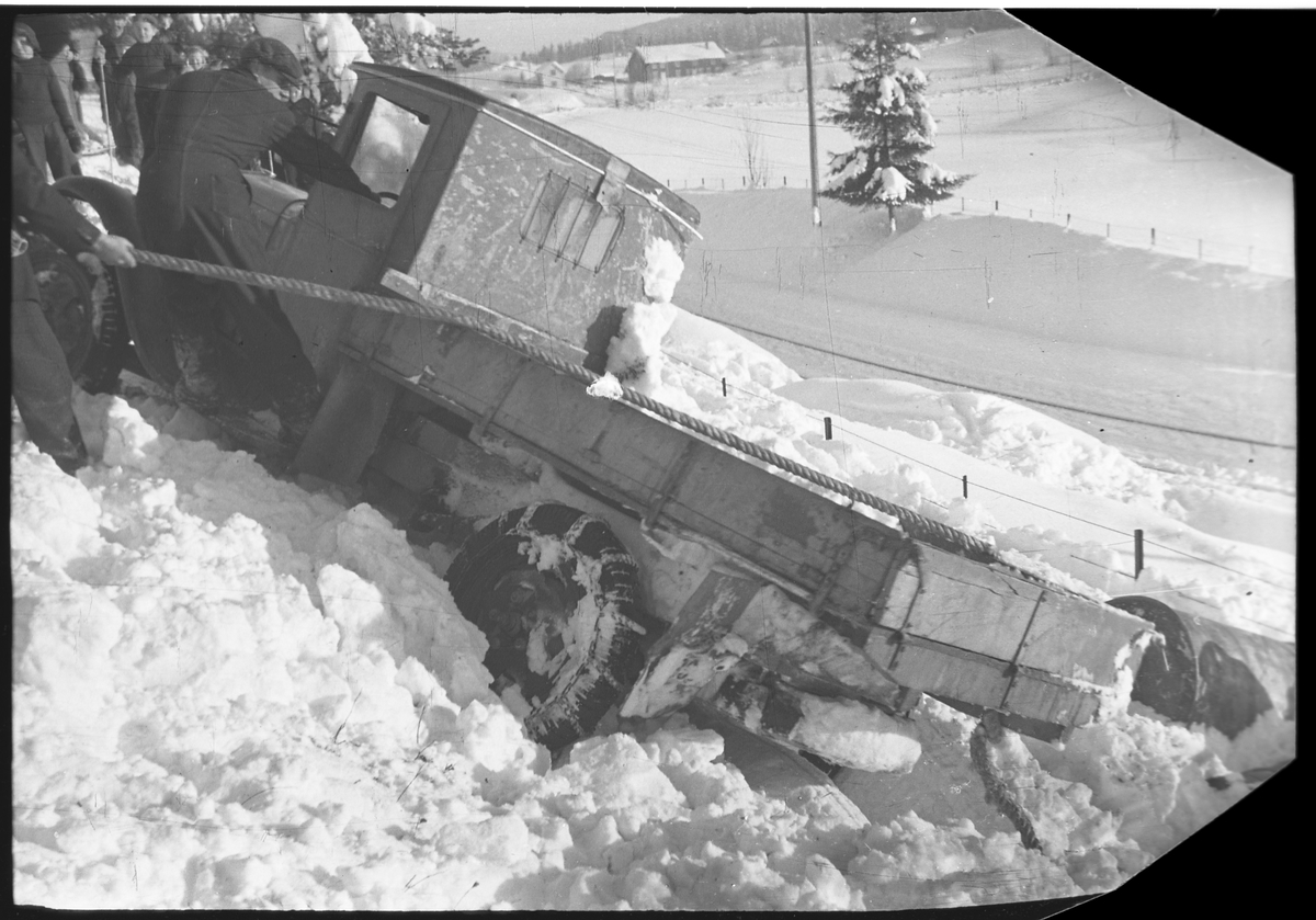 Lastebil av vegen på daværende riksveg 33, like syd for gården Smeby i Østre Toten vinteren 1939. Tre bilder. Ingen av personene er identifisert.