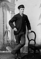 Portrett av en gutt eller mann. Fotografiet er tatt i atelie