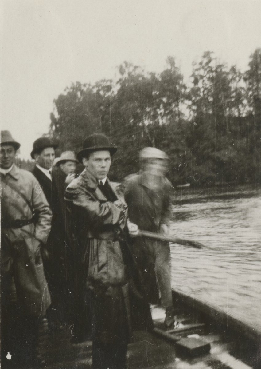 En grupp män samlade vid vatten.