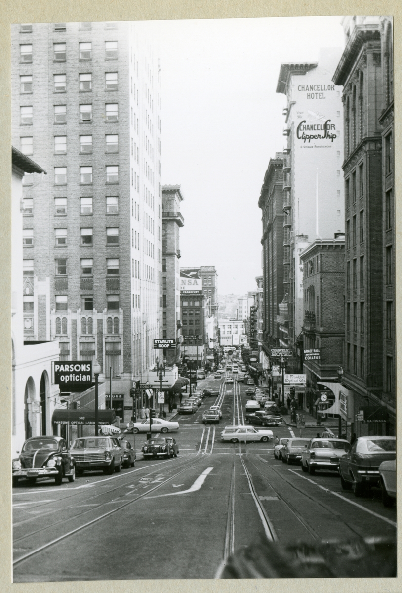 Bilden föreställer en vy över Powell Street i San Francisco med höghus, hotell, gator, skyltar och bilar. Bilden är tagen i samband med minfartyget Älvsnabbens långresa 1966-1967.