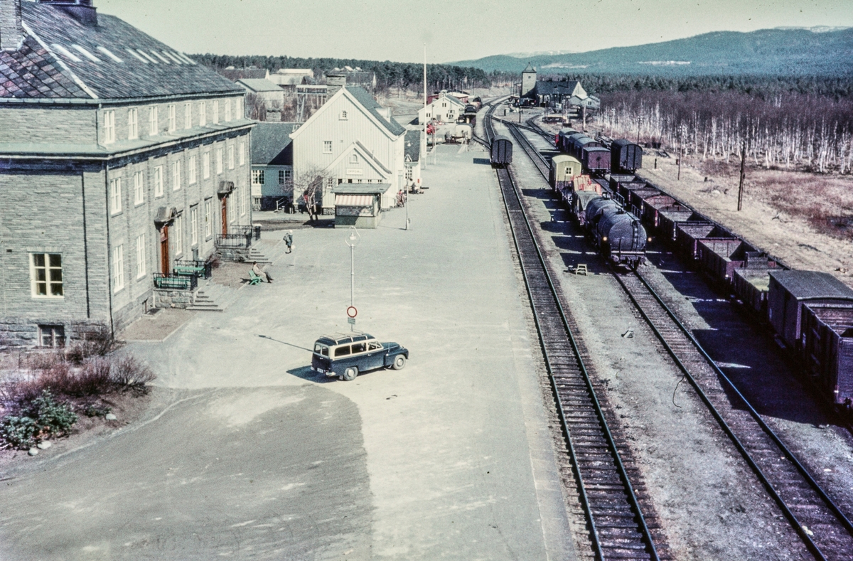 Oversiktsbilde fra Oppdal stasjon på Dovrebanen. Nærmest til venstre Oppdal Turisthotell, bak Oppdal stasjon. Et godstog skifter foran pakkhuset (bakerst til venstre). Bak til høyre sees lokomotivstall og svingskive.