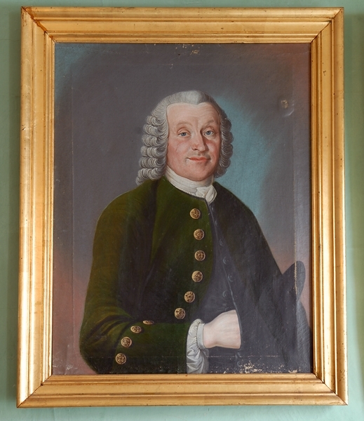 Porträtt i olja av adlig herre iförd mörkgrön rock med stora metallknappar och allongeperuk. Inom profilerad förgylld träram.