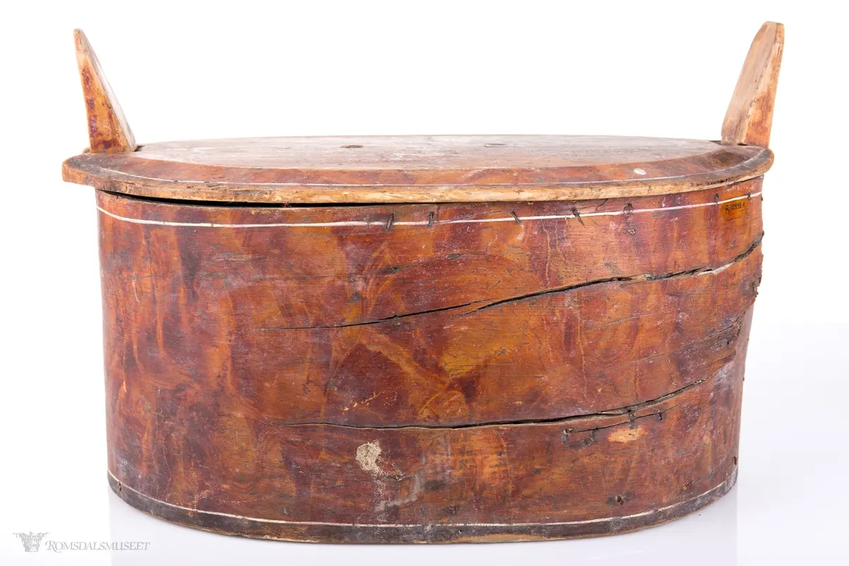 Hvite linjer langs kanten. Avrundet lokk. Innskrift.