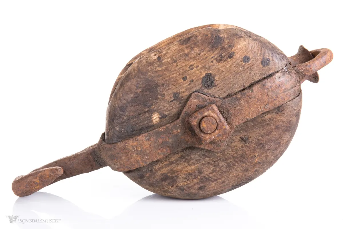 Treblokk med en enkelt skive eller trinse. Et kraftig jernbeslag griper om blokken og er festet med en gjennomgående bolt som er aksling for skiven. Beslaget avsluttets av en jernkrok på den ene siden og en jerning med en påfestet kause i den andre.