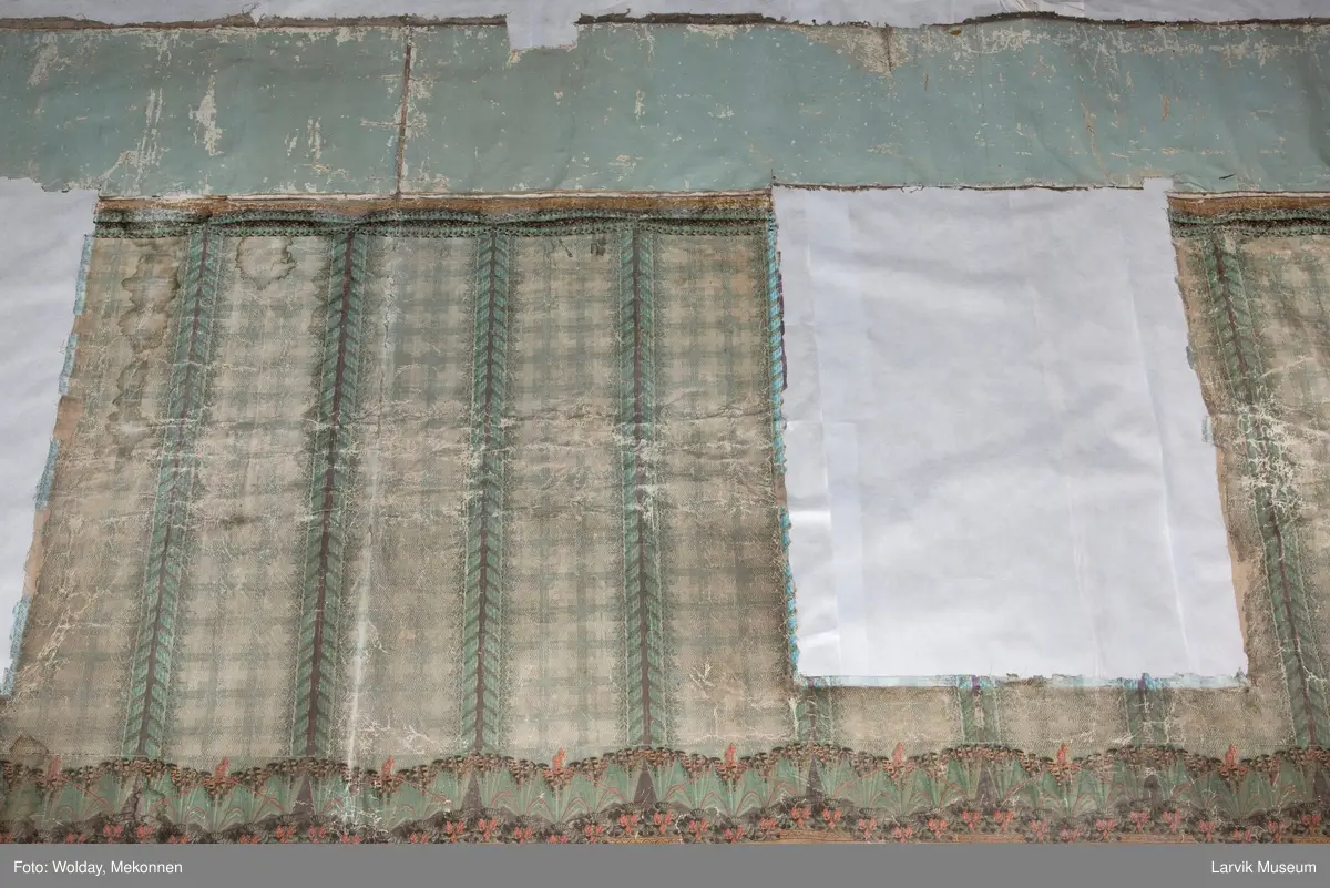 |Tapeten er påmalt tapetborder og brystning. Fra Hovland gård i Larvik.
Den øverste, brede borden: Gerlander/draperi med blomsterranker.
Den nederste, smalere borden: Tekstilbord med blomster. Øver døren til høyre: Stillebenmotiv med blomster og frukt.