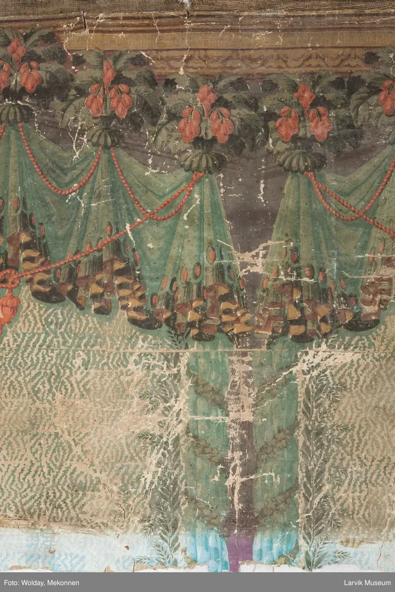 |Tapeten er påmalt tapetborder og brystning. Fra Hovland gård i Larvik.
Den øverste, brede borden: Gerlander/draperi med blomsterranker.
Den nederste, smalere borden: Tekstilbord med blomster. Øver døren til høyre: Stillebenmotiv med blomster og frukt.