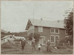 Fire personer foran Kinsarvikgården i Hardanger.