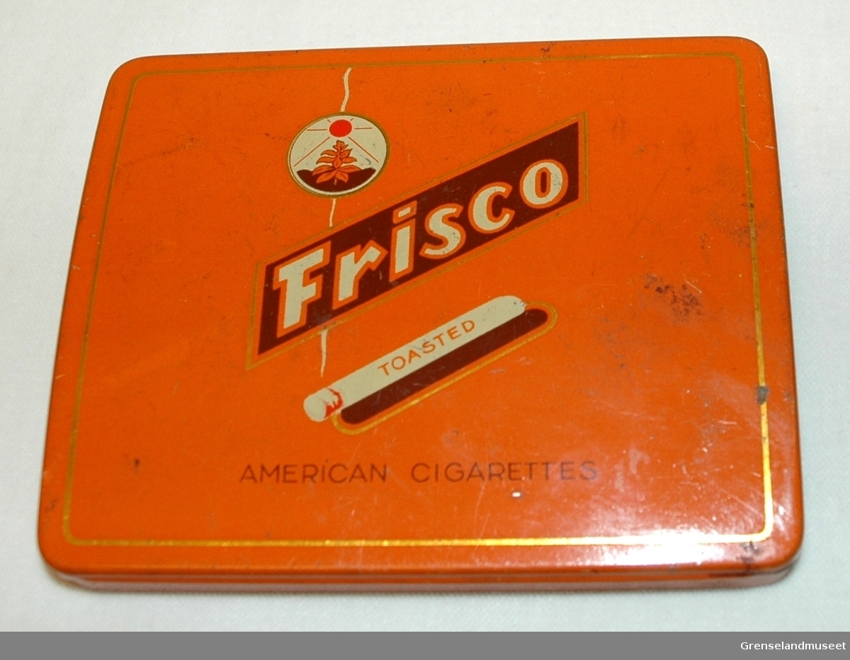 Orange blikkeske med påskrift Frisco toasted American cigarettes.
I esken ligger:2 reflekser til kattøyer, Diverse samlemerker for japansk ris, solgryn, diverse sigarettmerker