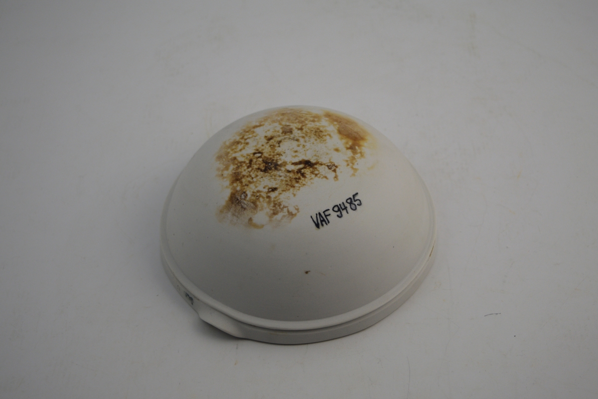 Sirkelformet hvit porselensskål med helle tut. Glasert inni og ca. 5 cm fra kanten utenpå - resten utenpå er uglassert. Skålen ble brukt til produksjon av legemidler, kanskje på vannbad.