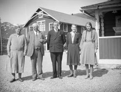 3 damer og 2 menn utenfor bygning på fjellet. Muligens ved E