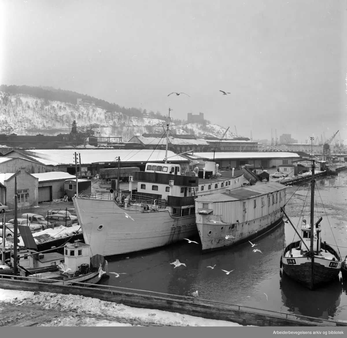 Sørenga. Paulsenkaia med husbåtene. På 1960- og 70-tallet drev Oslo Kommune og Kirkens Bymisjon disse båtene som et overnattingstilbud til hjemløse menn i hovedstaden. Den første båten ble åpnet i 1961 og lå til kai fram til 1984. Februar 1967.