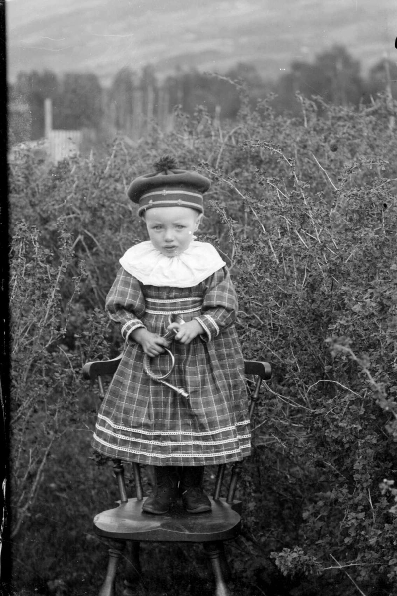 Liten jente, står på stol, holder en liten trompet , Kristian H. Grasmoens barn