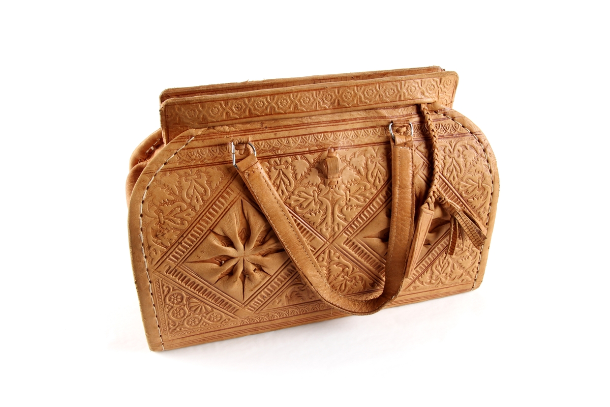 Håndveske i skinn med preget mønster.