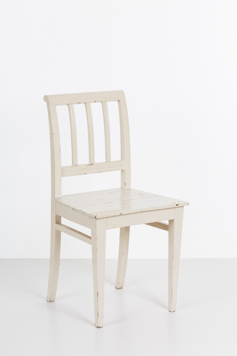 Hvitmalt spisestuestol. Sprosser i rygg og mellom stolbeina på venstre og høyre side.