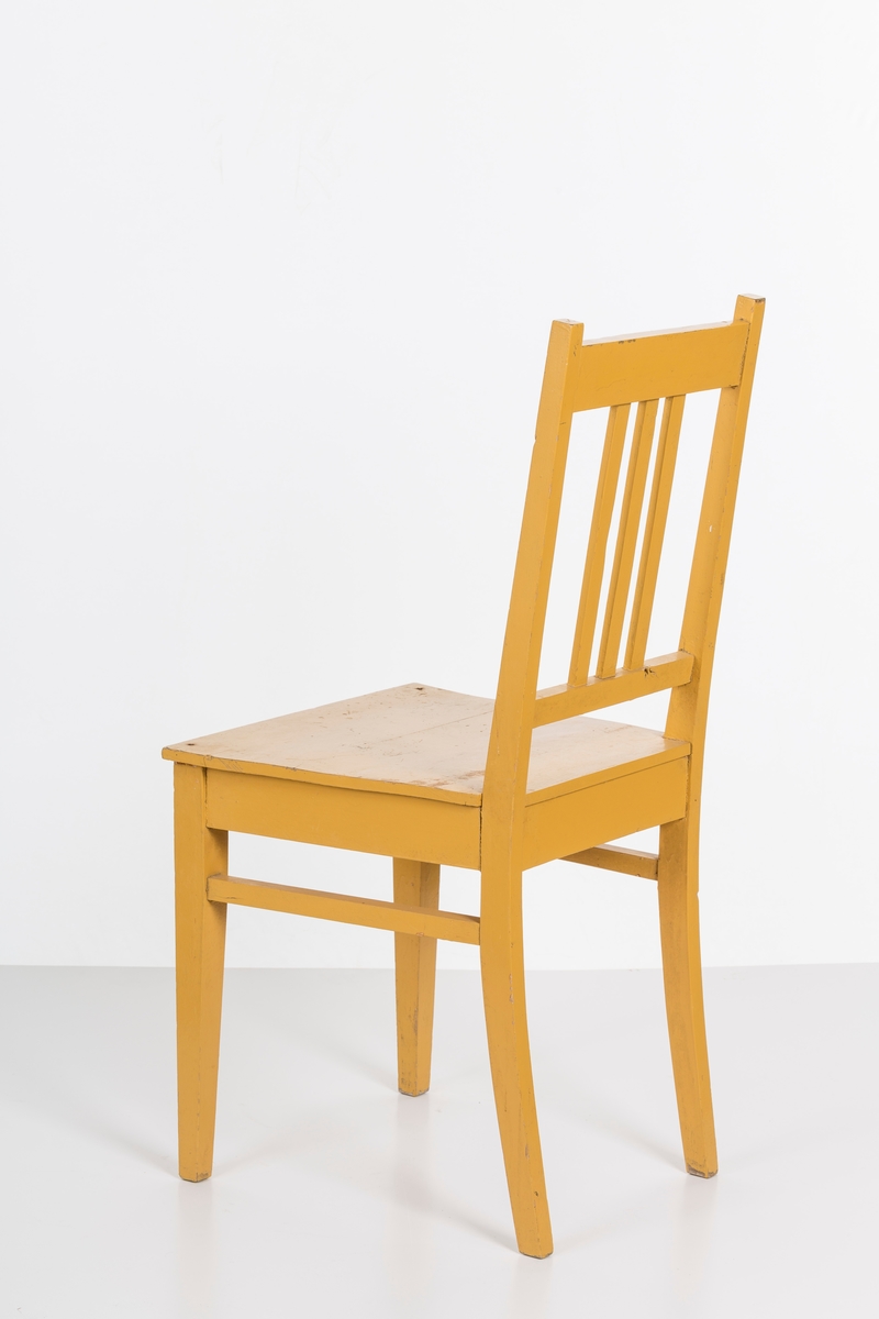 Stol i treverk, malt. Rygg med spiler. Den ene stolen har vært brukt betydelig røffere enn den andre.