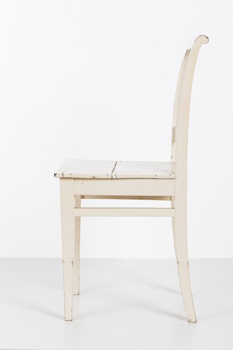 Hvitmalt spisestuestol. Sprosser i rygg og mellom stolbeina på venstre og høyre side.