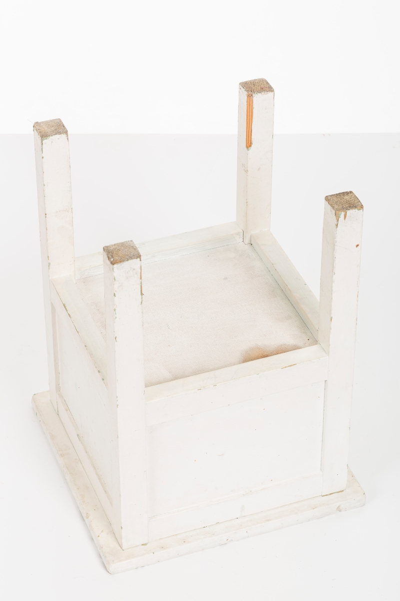 Hvitmalt krakk med oppbevaringsrom. Åpnes fra oversiden.