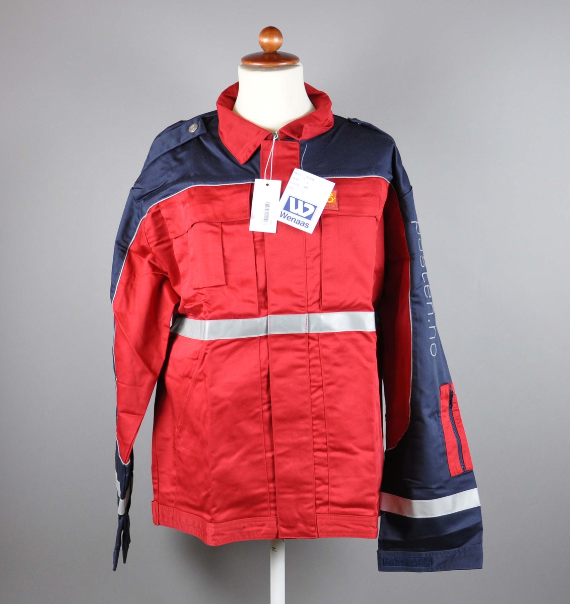 Rød uniformsjakke med postlogo. 4 lommer + lomme for mobil og for penner. Refleksbånd på ermer og liv. Skulderklaffer med knapper med posthorn.

Størrelse 50.