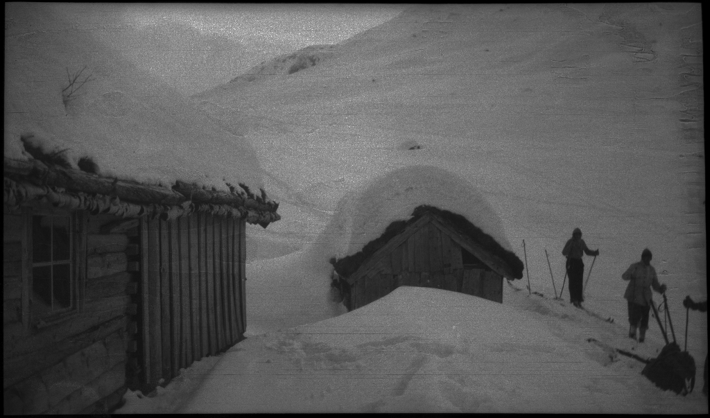 En guttegjeng på skitur i fjellene ovenfor Saudasjøen. Det er bilder av gjengen som går oppover bakkene, og fra en pause ved en gammel hytte.
