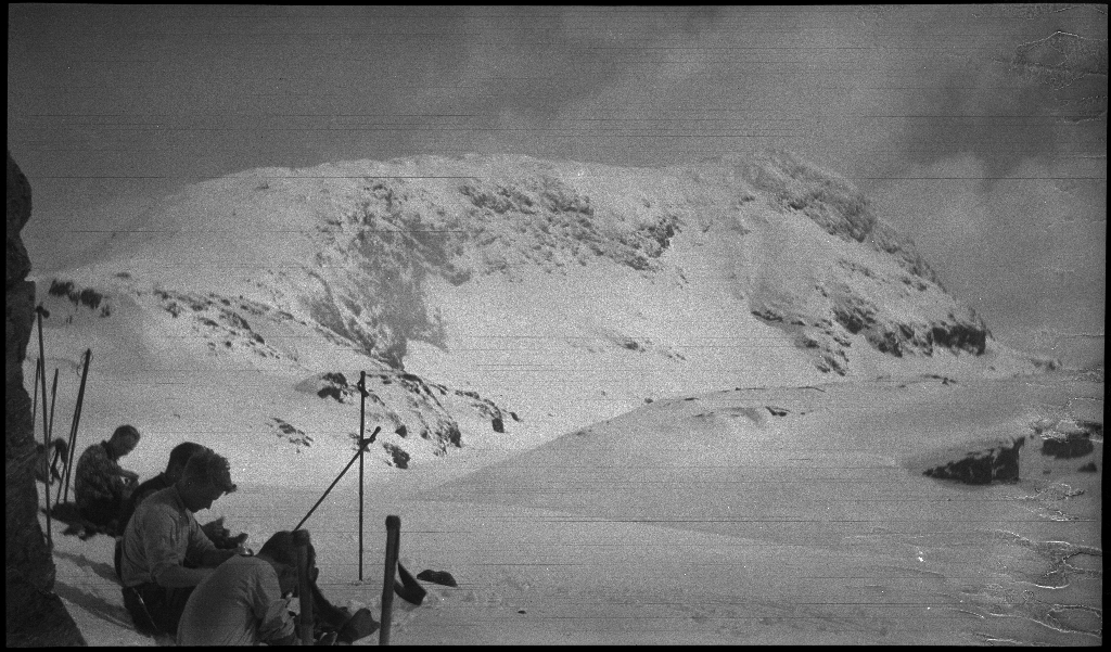 Fire unge menn på skitur påsken 1936. De har laget en bil av snø med bobleform (kanskje inspirert av Porsche Typ 1 fra 1935). Det er også bilder fra flere fjelltopper, fra skigåing og fra ei turisthytte.