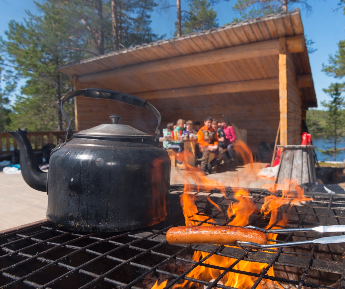 Bilder fra Blokkodden Villmarksmuseum ved Drevsjøen i Engerdal, Hedmark.  Pølsegrilling og kaffekoking på festplassen. Grilling. Svartkjele. Kaffekjele. Skoleelever fra Engerdal barneskole og Sømodalen barneskole.