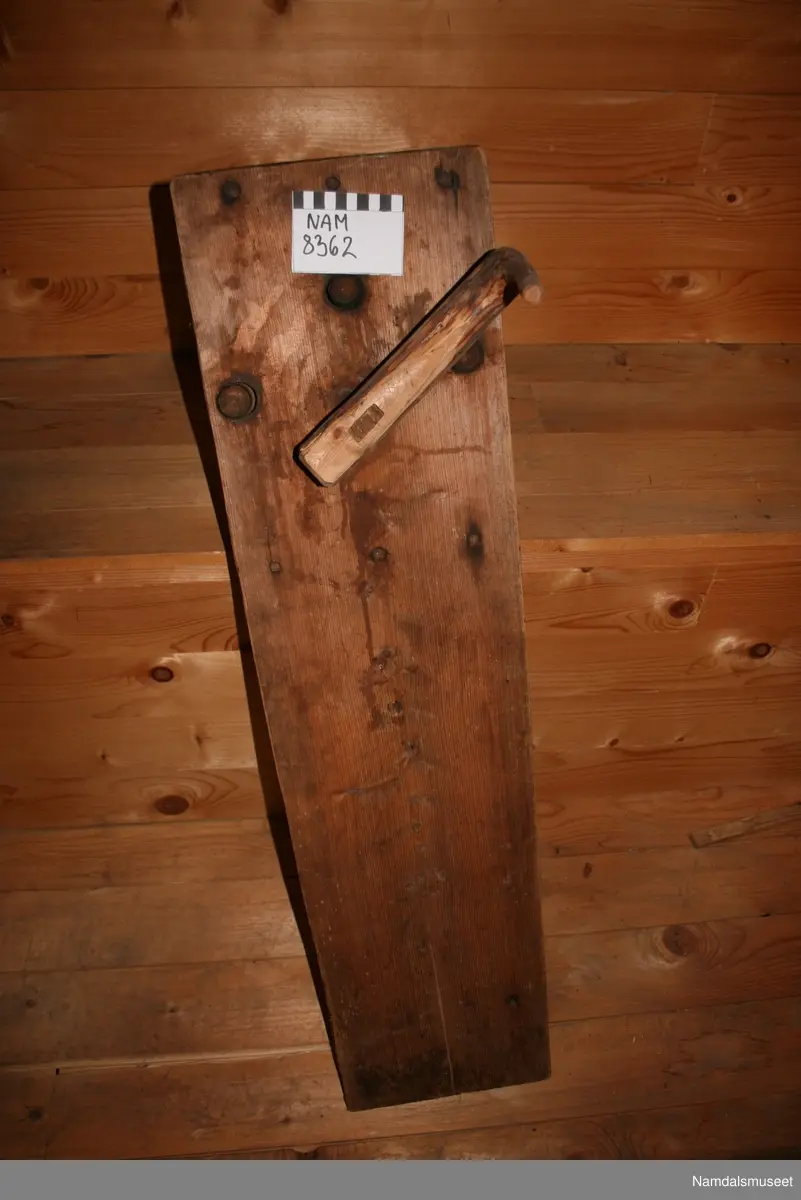 Form: Fjøl med sveiv og tannhjul som drar tre kroker rundt
