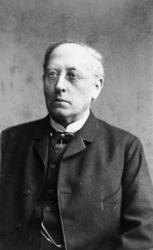 Portrett, mann med briller, slipsnål, urkjede.  Kristiansund