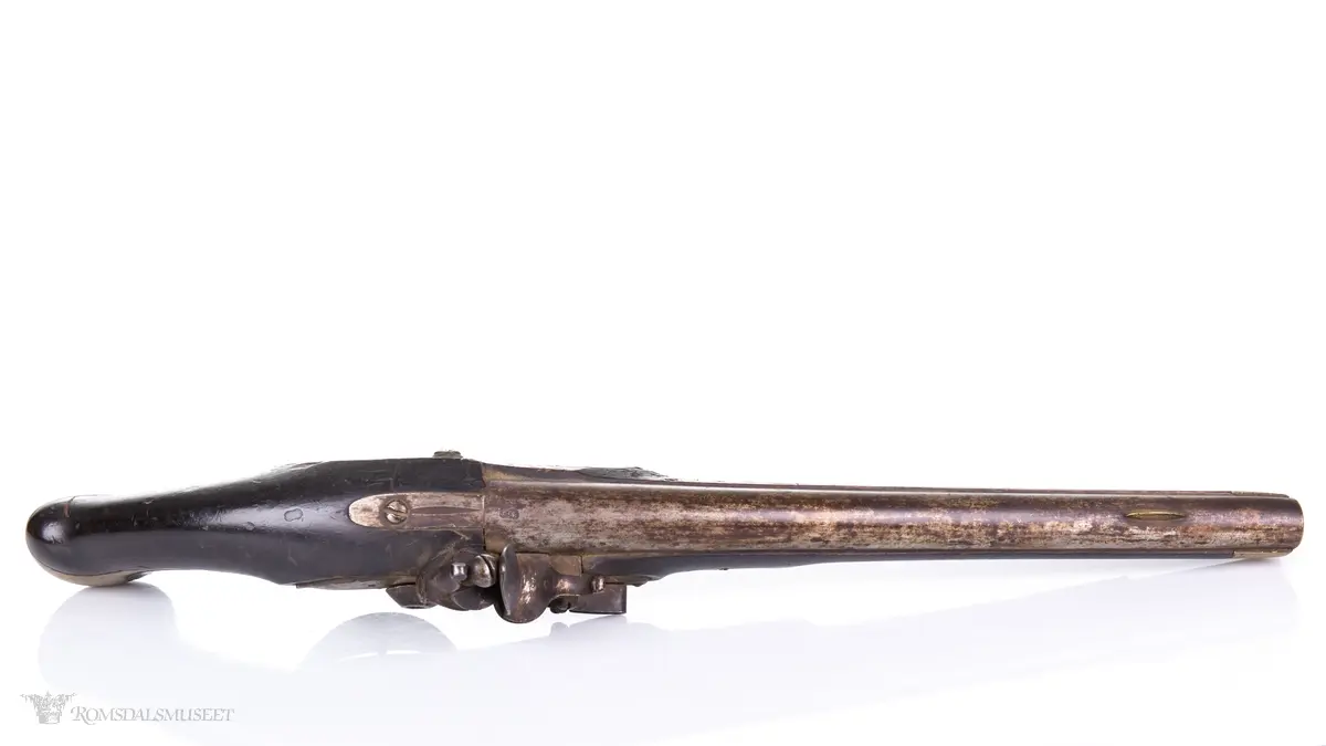 Flintlåspistol med glattboret løp, uten baksikte og med åpent korn. Skjefte av bøk med messingbeslag i enden og ved munningen. To røkner med ladestokk.
