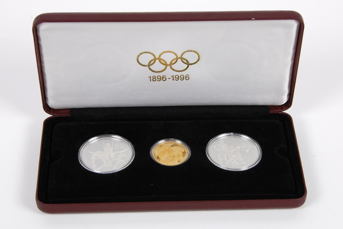 Myntsett bestående av en gullmynt og to sølvmynter. Sølvmyntene er canadiske 15-dollarmynter med motiv av Elizabeth den 2 i profil på den ene siden. Gullmynten er en australsk 175-dollarmynt, også med motiv av Elisabeth den 2. i profil. Myntene er kapslet inn i hardplast og ligger i en vinrød eske. Esken har et hvitt omslag av papp med de olympiske ringene i gull.